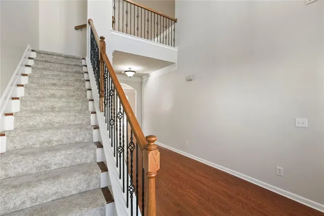 a view of staircase with wooden floor and white walls