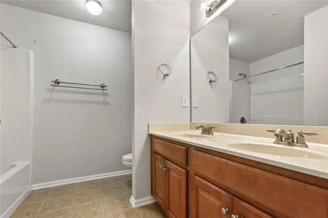 a bathroom with a granite countertop sink a toilet and a mirror