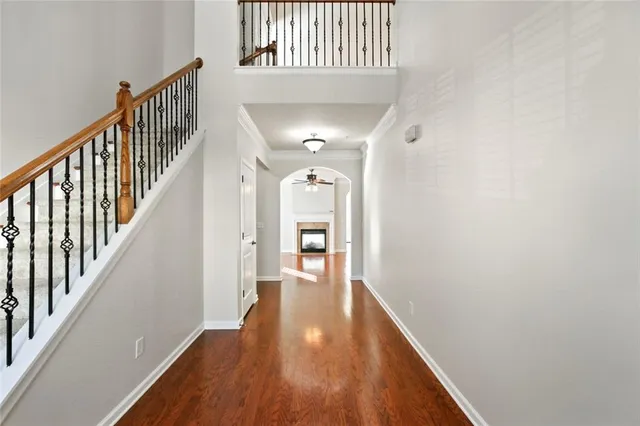 a view of a hallway with wooden floor and staircase