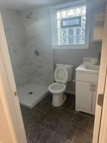 a bathroom with a toilet and a shower