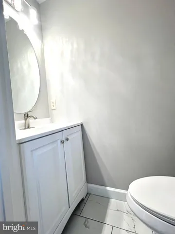 a bathroom with a sink mirror vanity and toilet