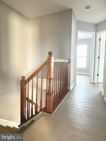 a view of a hallway with wooden floor and entryway