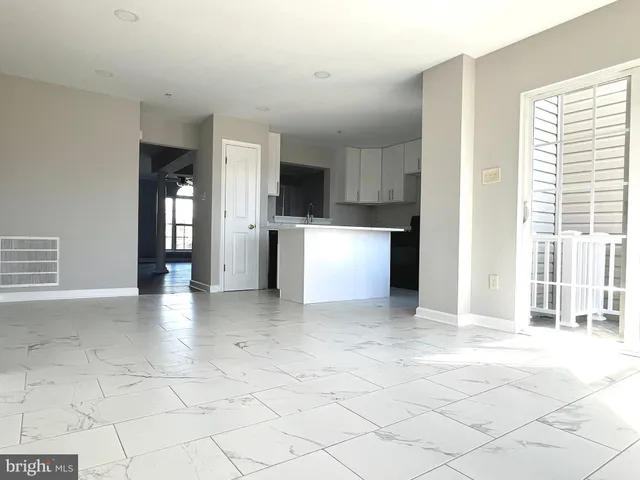 a view of an empty room with a kitchen