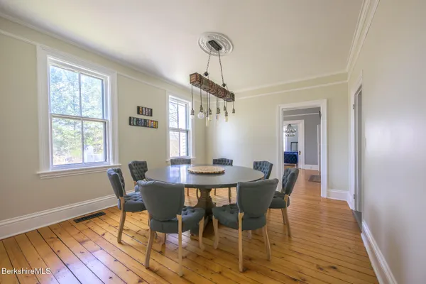 a kitchen with kitchen island granite countertop a table chairs refrigerator and sink