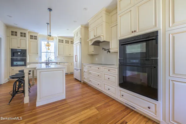 a kitchen with a sink and wooden floor