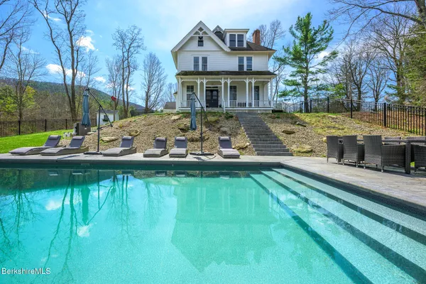 a front view of a house with swimming pool having outdoor seating
