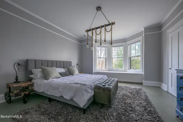 a bed sitting in a bedroom next to a window