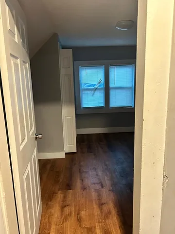 a view of a small space with wooden floor and a window