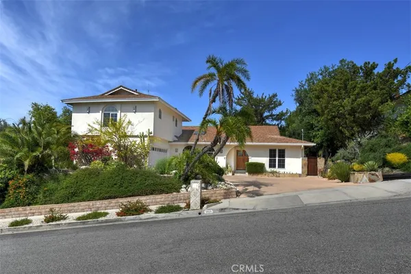 a front view of a house with a yard and potted plants