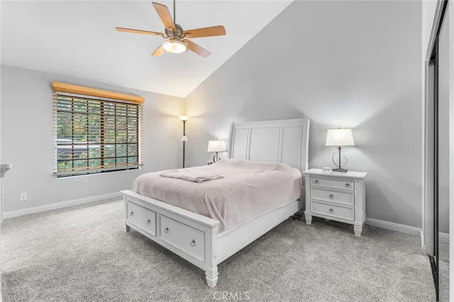 a spacious bedroom with a bed and a ceiling fan