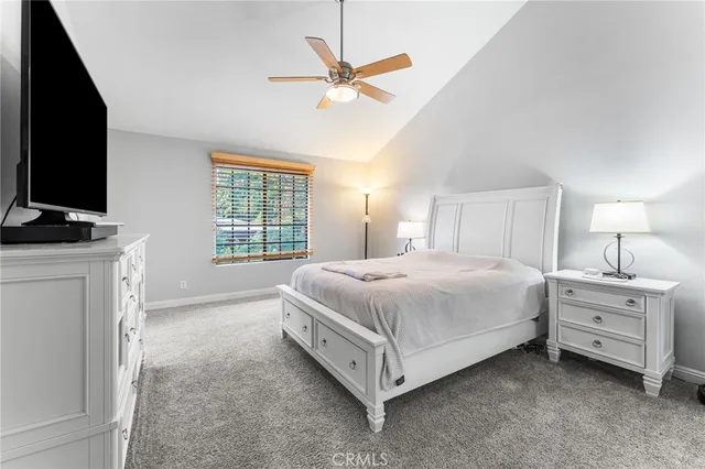 a spacious bedroom with a bed and a flat screen tv