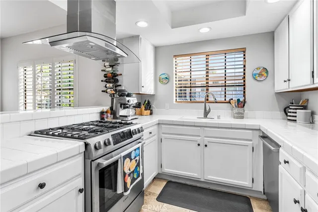 a kitchen with stainless steel appliances a stove a sink and a window