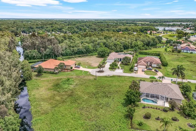 an aerial view of residential houses with outdoor space and trees