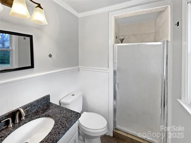 a bathroom with a granite countertop sink mirror vanity and toilet