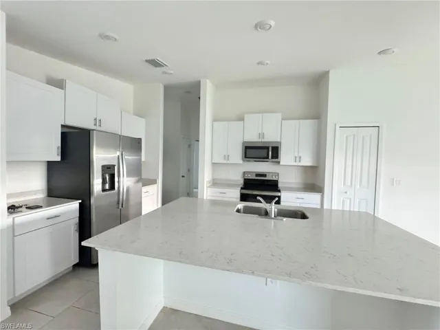 a kitchen that has a stove a microwave and a refrigerator