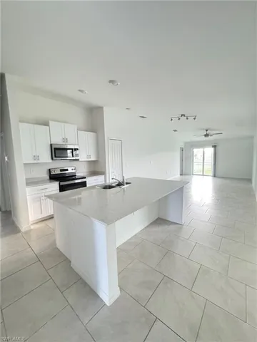 a kitchen with stainless steel appliances a sink a stove a microwave and a refrigerator