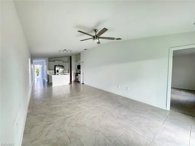 a view of a big room with a chandelier fan and windows