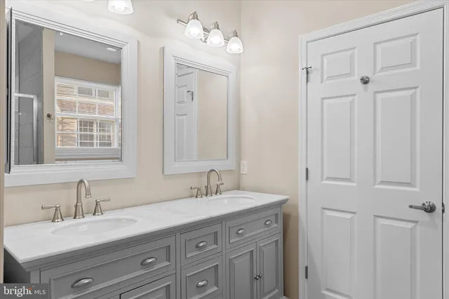 a bathroom with double vanity sink a vanity and a mirror