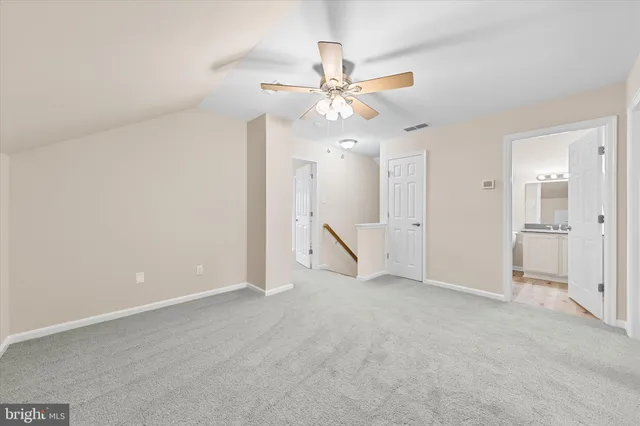 an empty room with closet and a ceiling fan