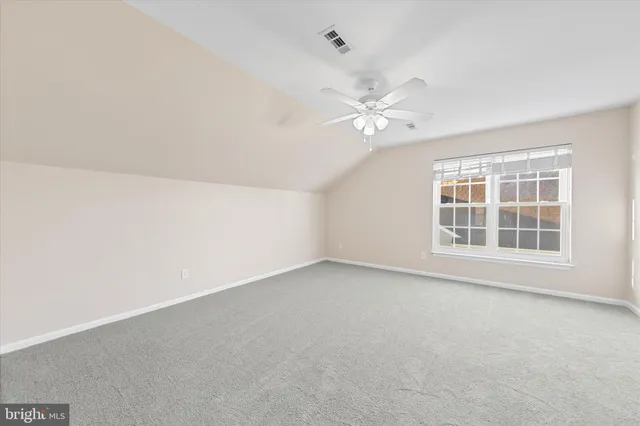 an empty room with a window and a ceiling fan