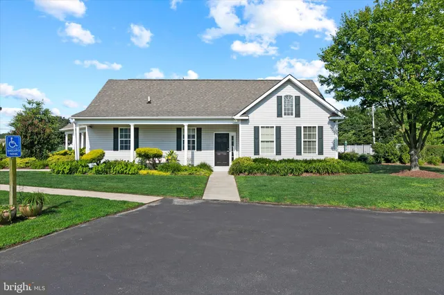 a backyard of a house with table and chairs under an umbrella