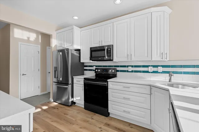 a kitchen with a refrigerator stove and sink