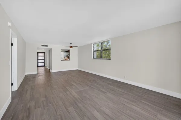 a view of empty room with wooden floor and window