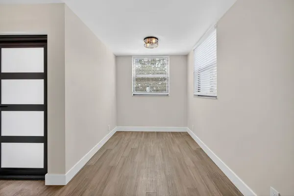 an empty room with a window and wooden floor