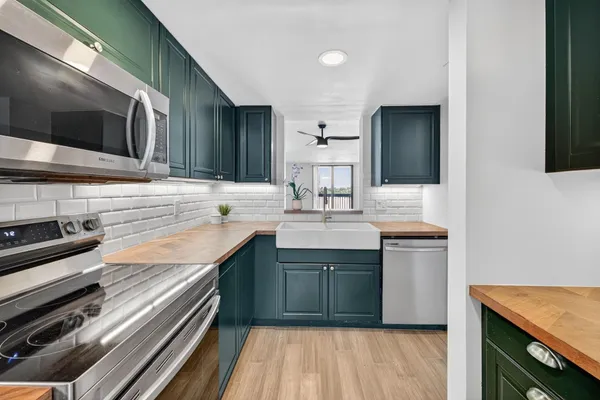 a kitchen with stainless steel appliances granite countertop a sink and a stove