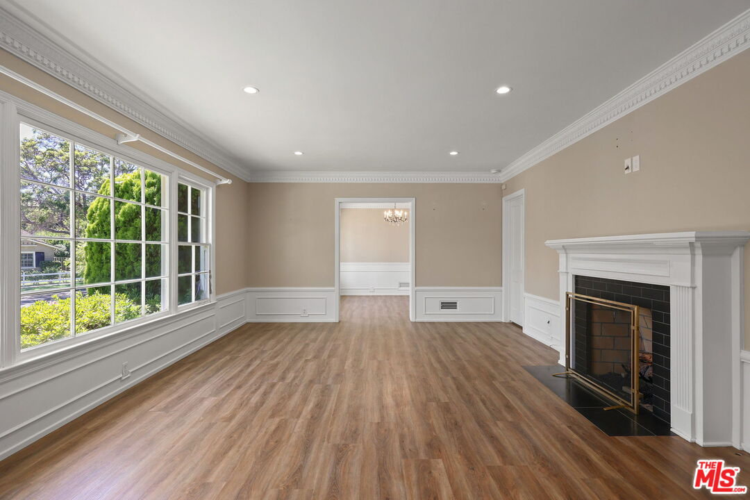 15415 Albright Street Pacific Palisades, CA 90272 - Photo 4 of 21 a view of empty room with wooden floor and fireplace
