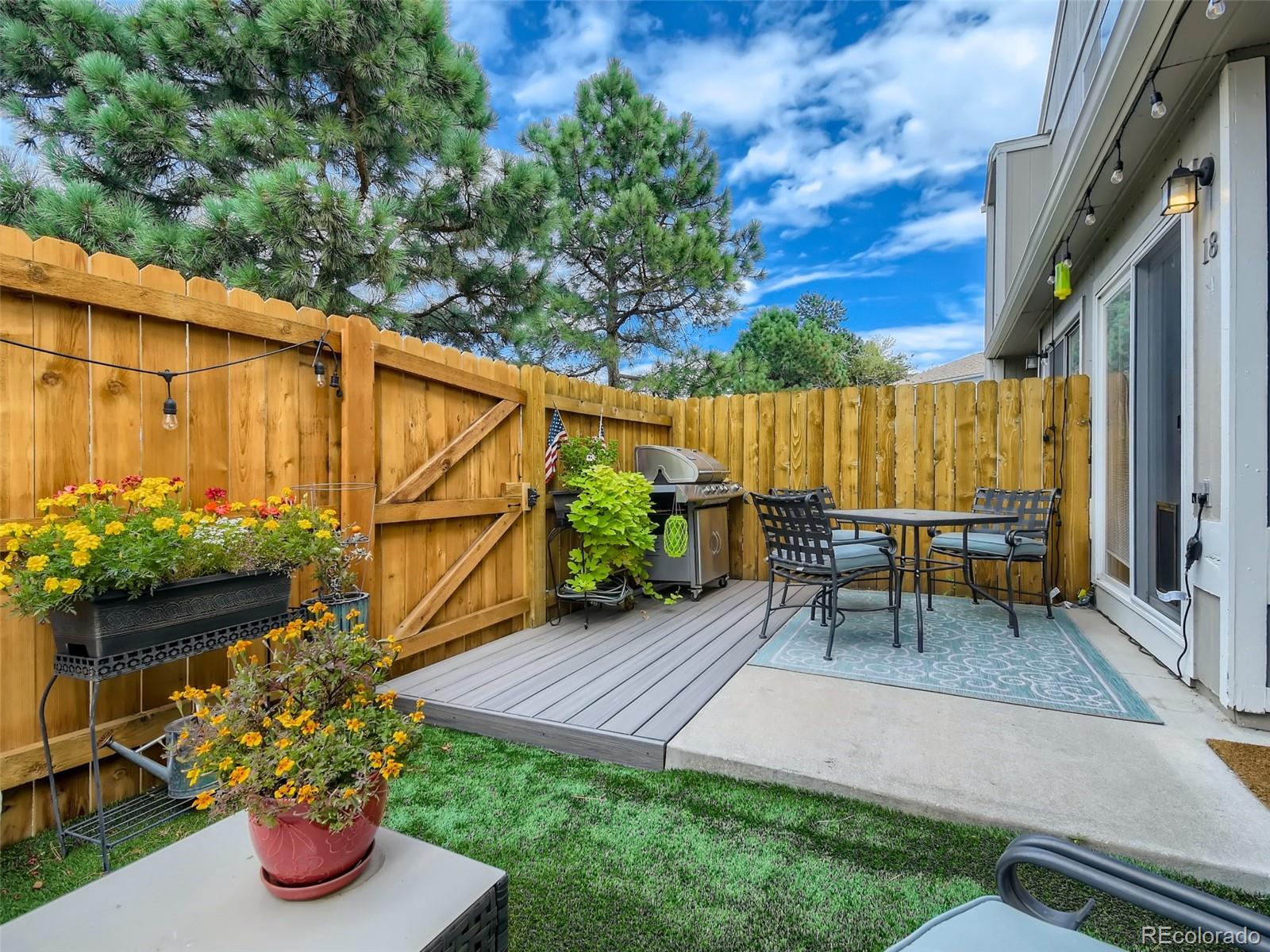 7994 Chase Circle, Unit 18 Arvada, CO 80003 - Photo 14 of 15 a view of backyard with table and chairs potted plants and wooden fence