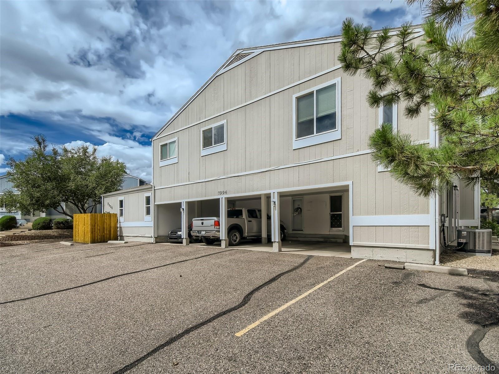 7994 Chase Circle, Unit 18 Arvada, CO 80003 - Photo 15 of 15 front view of a house with a yard and potted plants