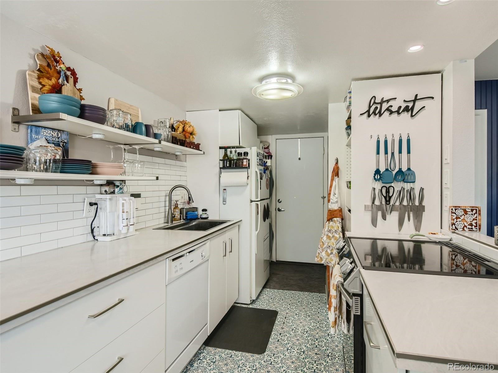 7994 Chase Circle, Unit 18 Arvada, CO 80003 - Photo 7 of 15 a kitchen with a sink a refrigerator and cabinets