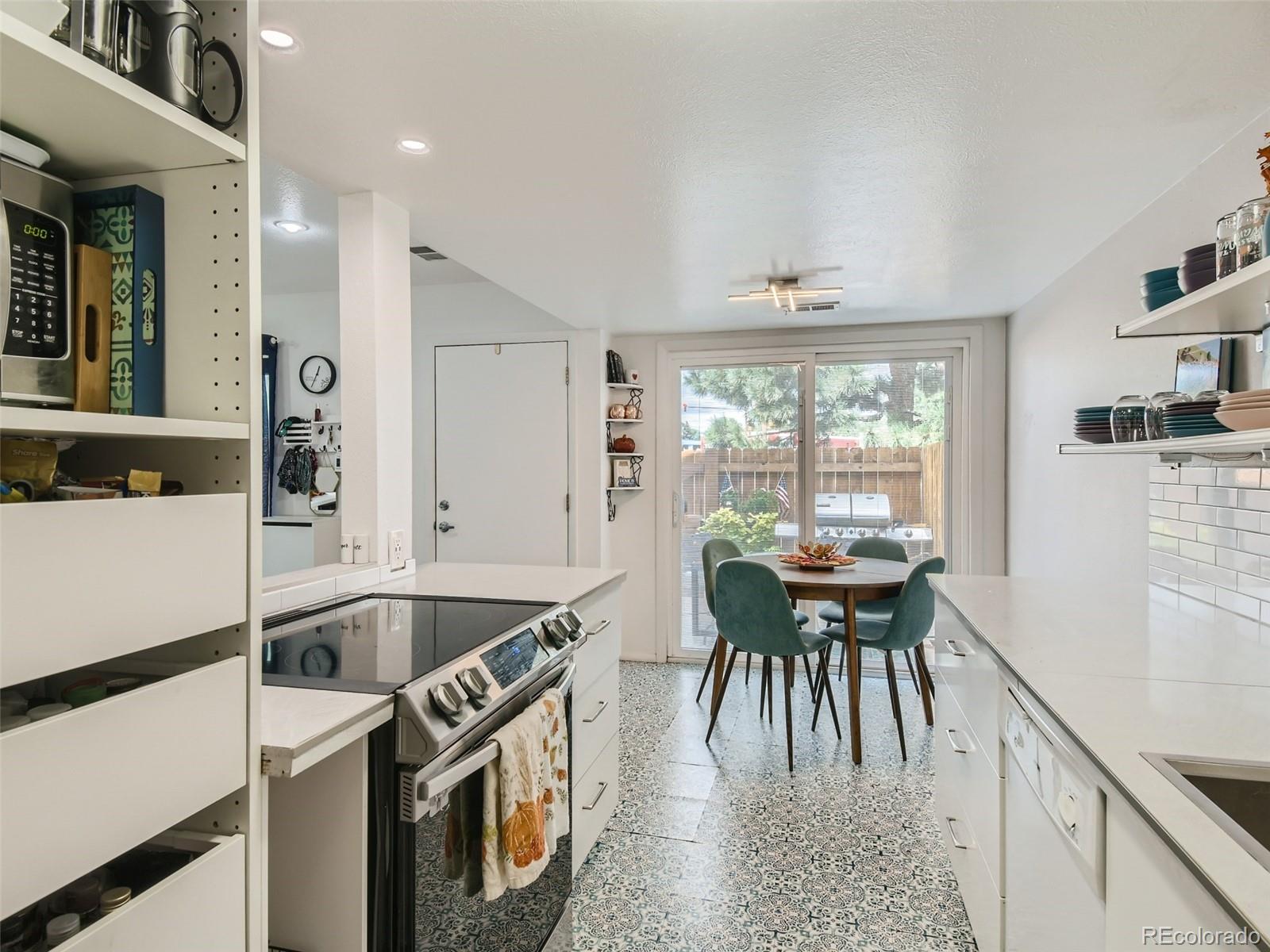 7994 Chase Circle, Unit 18 Arvada, CO 80003 - Photo 9 of 15 a kitchen with a stove a refrigerator and a dining table with wooden floor