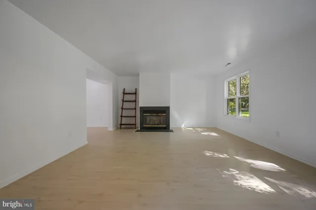 an empty room with a fireplace and lots of windows