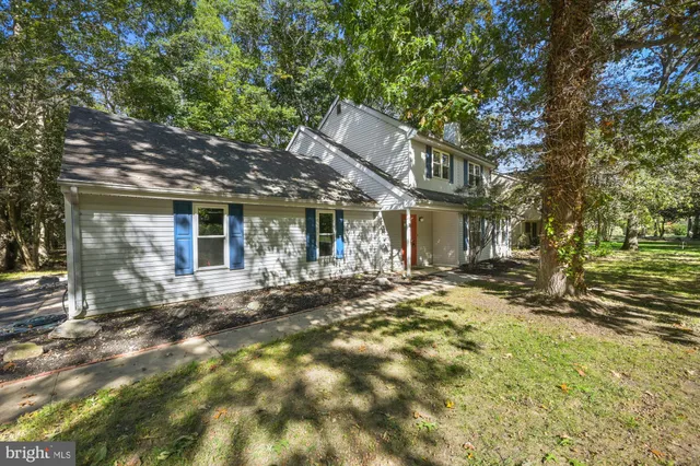 a view of a house with large tree and wooden fence