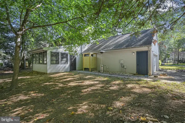 a view of a house with a garden and trees