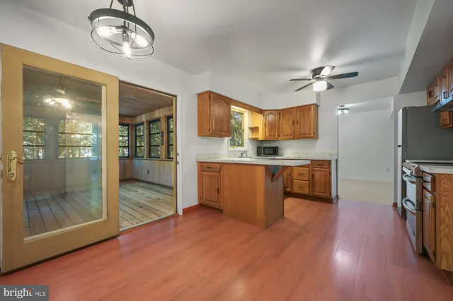 a kitchen with stainless steel appliances granite countertop a refrigerator a stove and a wooden floors