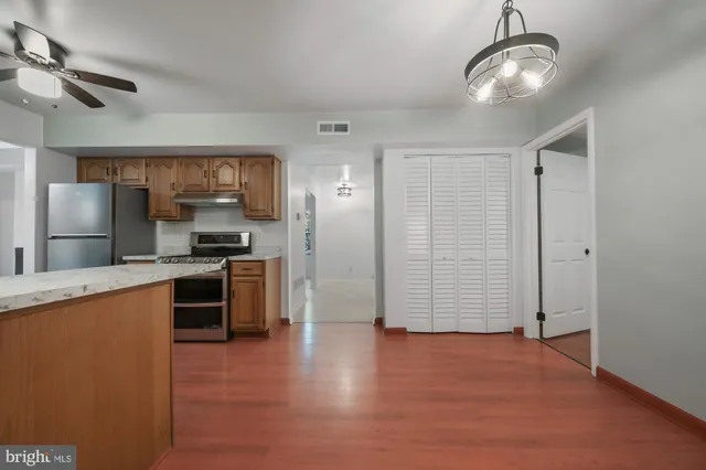 a view of kitchen with stainless steel appliances granite countertop cabinets and refrigerator