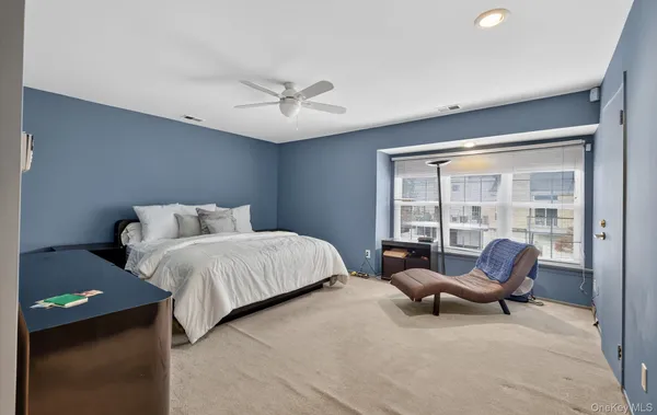 a spacious bedroom with a bed and chair