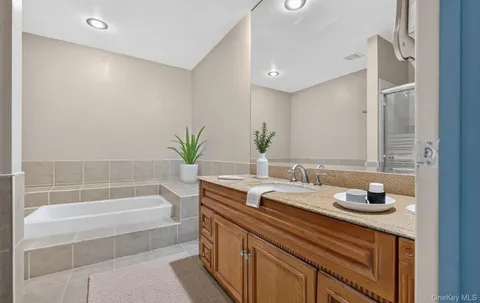 a bathroom with a granite countertop sink a toilet and bathtub