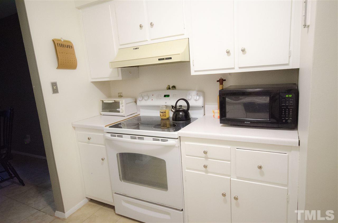 1245 Schaub Drive, Unit 1245 Raleigh, NC 27606 - Photo 3 of 10 a stove top oven sitting inside of a kitchen