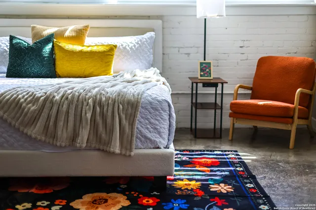 a bed sitting in a bedroom next to a lamp