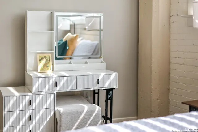 a bedroom with a bed a chair and potted plant