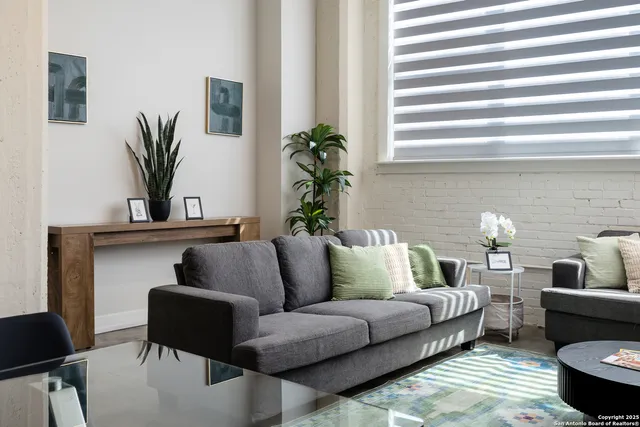 a living room with furniture and a potted plant