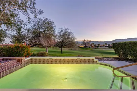 a view of swimming pool with a patio and a yard