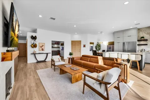 a kitchen with granite countertop a table chairs stove and refrigerator