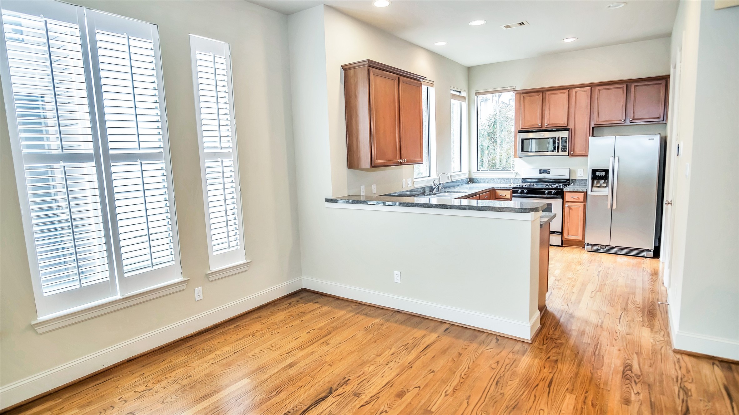 1611 Silver Street Houston, TX 77007 - Photo 11 of 32 a kitchen with stainless steel appliances granite countertop a stove a sink a refrigerator with wooden cabinets and wooden floor