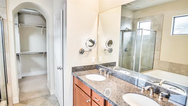 a bathroom with a granite countertop sink a mirror and shower