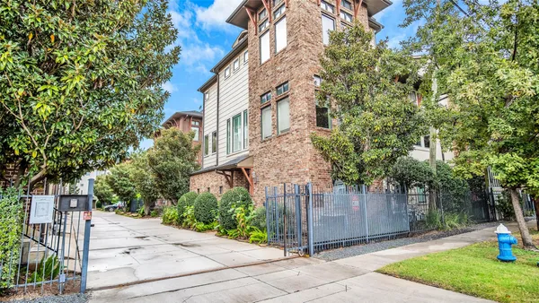 a view of a street with brick wall and plants